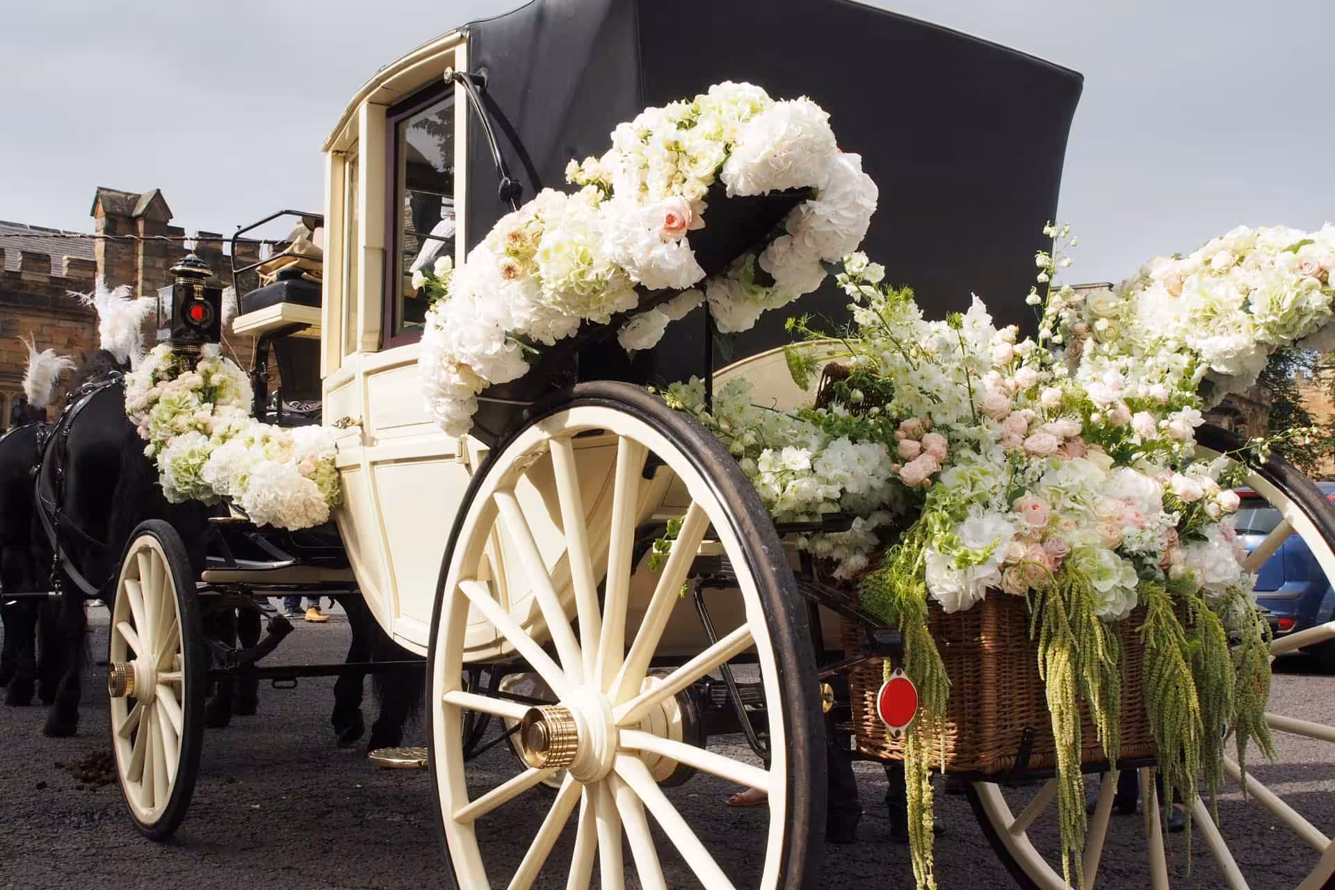 A wedding carriage drawn by four horses, waiting outside.